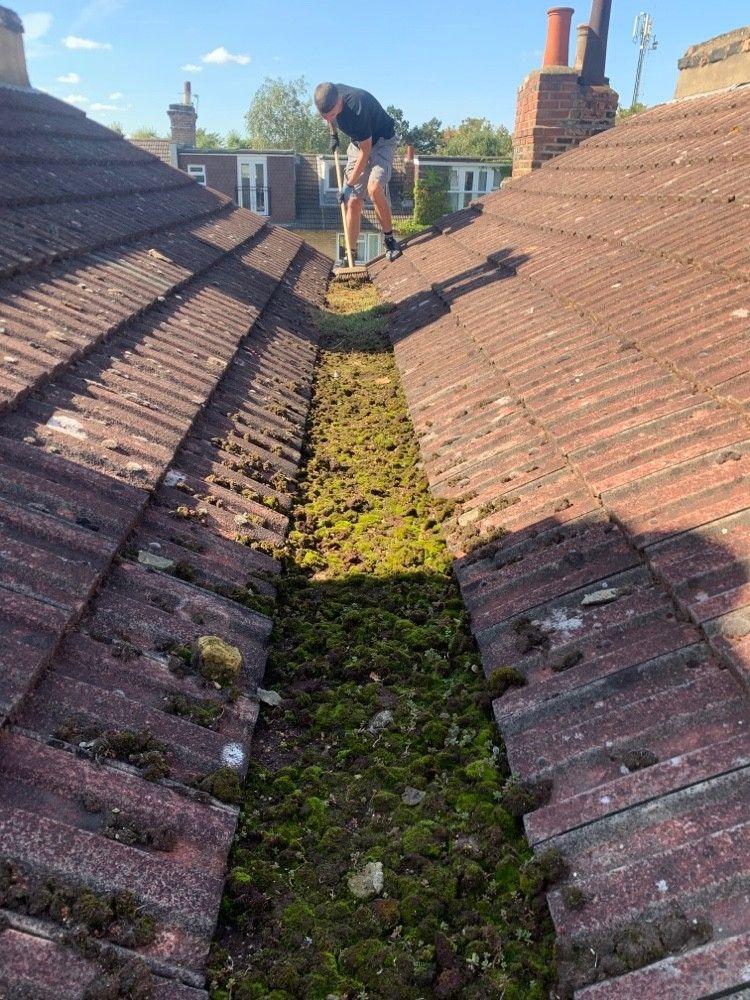 Moss-filled roof valley, before