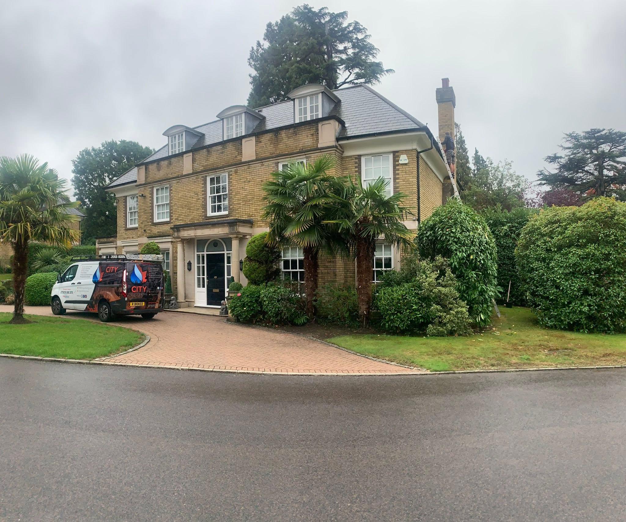 City Guttering van and crew working on a gutter clean at a London property